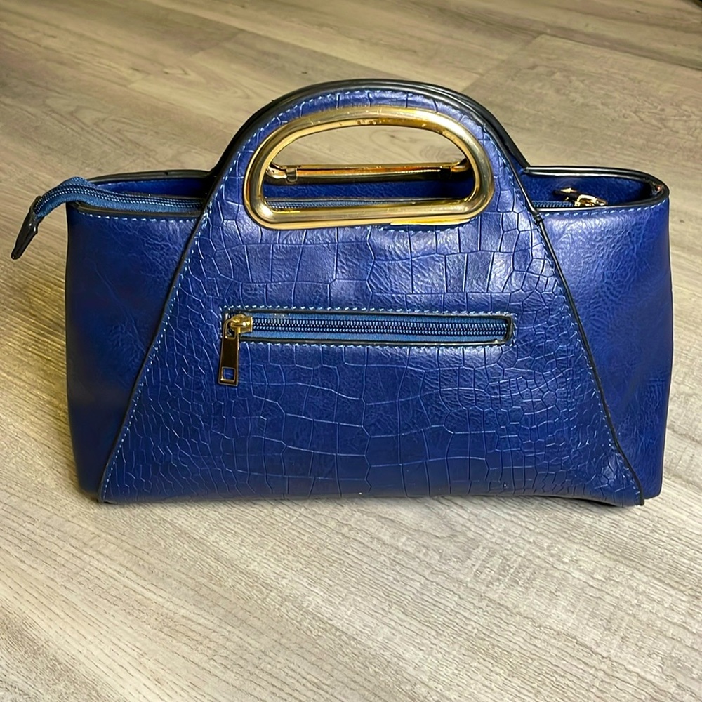 Modern small navy blue hand bag, light weight, with a small pocket in the front.